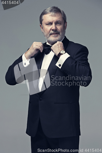 Image of Middle aged male adult wearing a suit isolated on gray