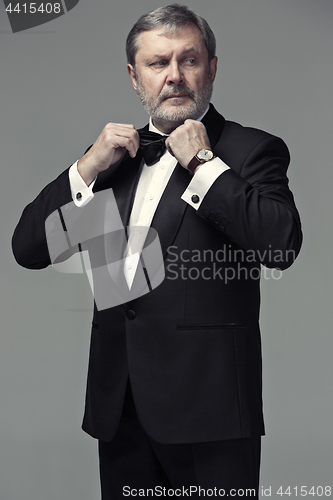 Image of Middle aged male adult wearing a suit isolated on gray