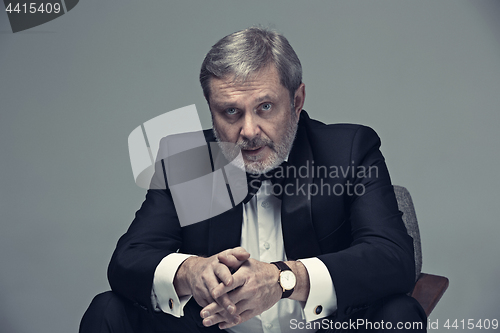 Image of Senior Businessman sitting in chair