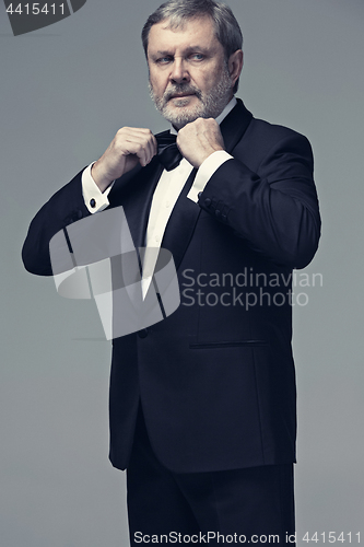 Image of Middle aged male adult wearing a suit isolated on gray