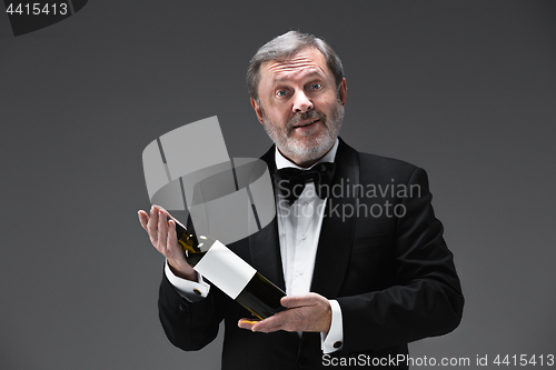 Image of professional waiter in uniform is serving wine