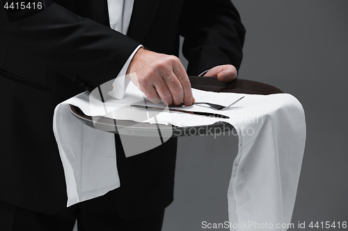 Image of Senior waiter holding tray