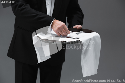 Image of Senior waiter holding tray