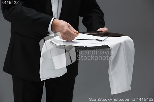 Image of Senior waiter holding tray