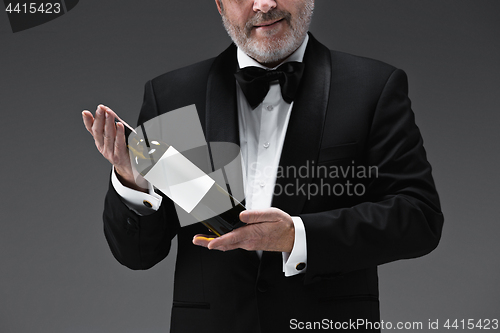 Image of professional waiter in uniform is serving wine