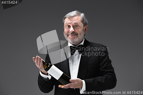 Image of professional waiter in uniform is serving wine