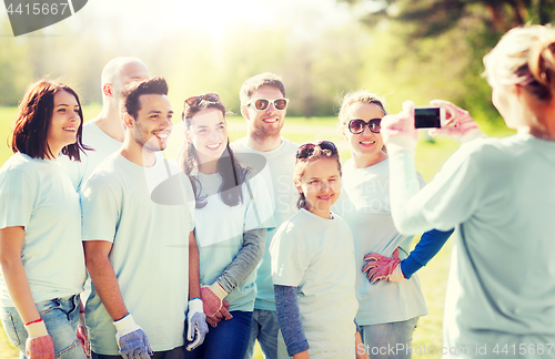 Image of group of volunteers taking picture by smartphone