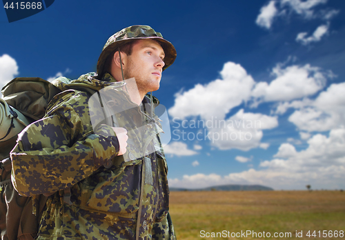 Image of soldier in military uniform with backpack hiking