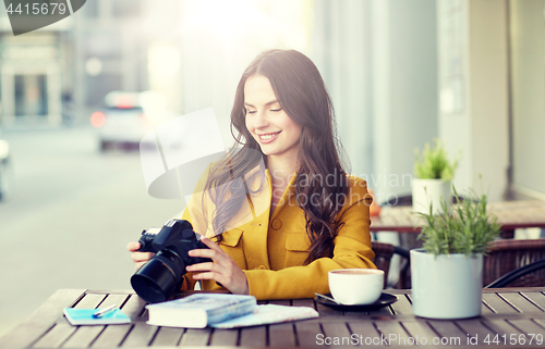 Image of happy tourist woman with camera at city cafe