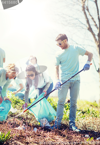 Image of volunteers with garbage bags cleaning park area