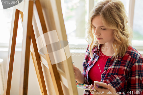 Image of teenage girl with smartphone at art school studio