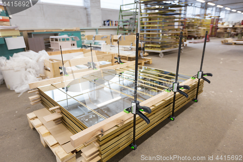 Image of mirror panels with bar clamps at furniture factory