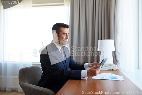 Image of businessman with tablet pc working at hotel room