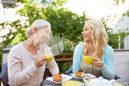 Image of daughter with senior mother drinking tea at cafe