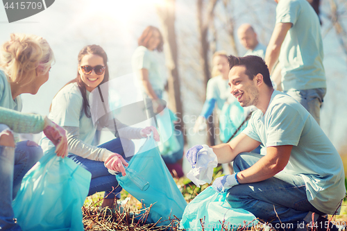 Image of volunteers with garbage bags cleaning park area