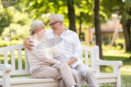 Image of happy senior couple sitting on bench at park