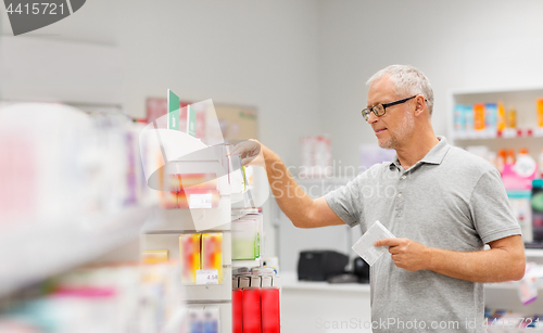 Image of senior male customer with drug at pharmacy