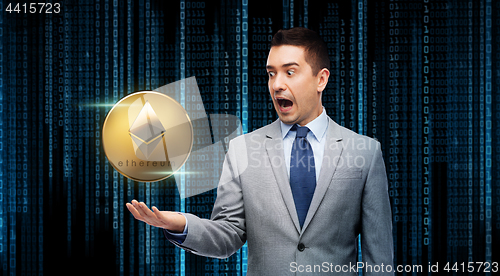 Image of excited businessman with etherum over binary code