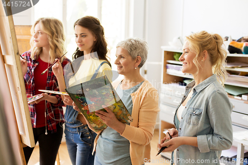 Image of women with brushes painting at art school