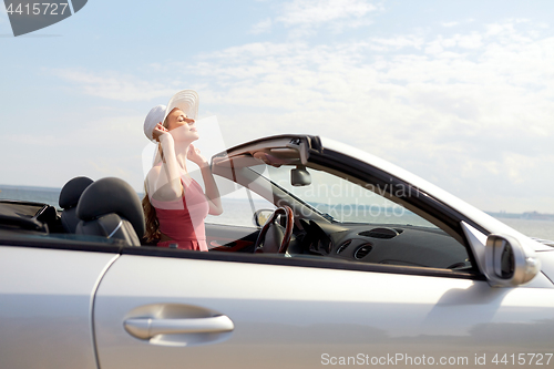 Image of happy young woman in convertible car