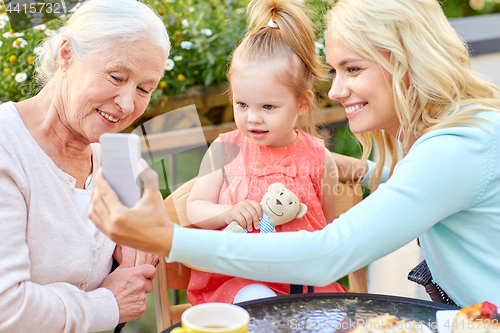 Image of happy family taking selfie at cafe