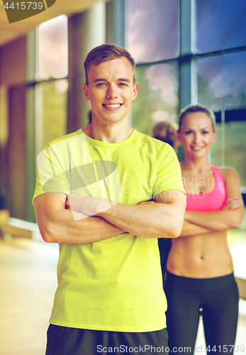 Image of smiling man and woman in gym