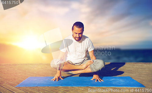 Image of man doing yoga scale pose outdoors