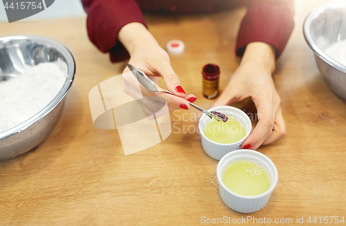 Image of chef adding food color into bowl with egg whites