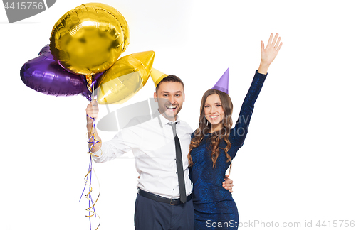 Image of happy couple with party caps and balloons