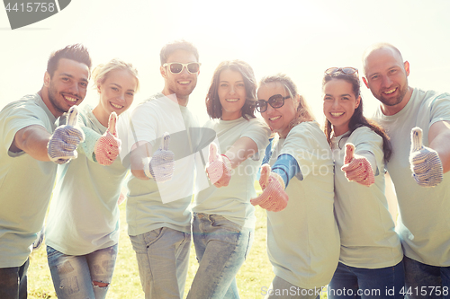 Image of group of volunteers showing thumbs up outdoors