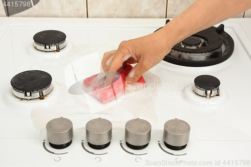 Image of hand cleaning gas cooker