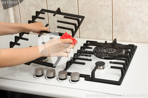 Image of hands cleaning gas cooker