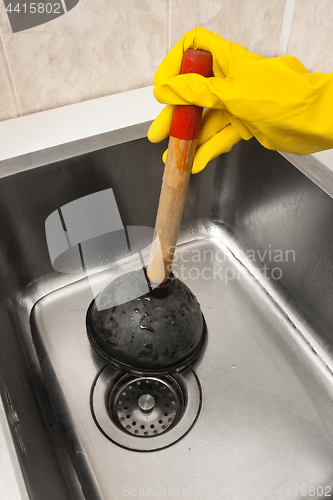 Image of hand in glove using a plunger