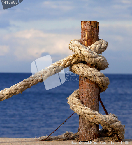 Image of Rope on seafront and cloudy sky in autumn evening