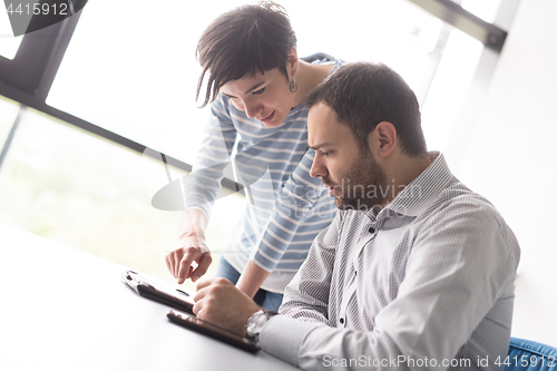 Image of Two Business People Working With Tablet in startup office