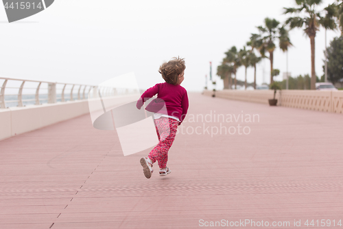 Image of cute little girl on the promenade by the sea