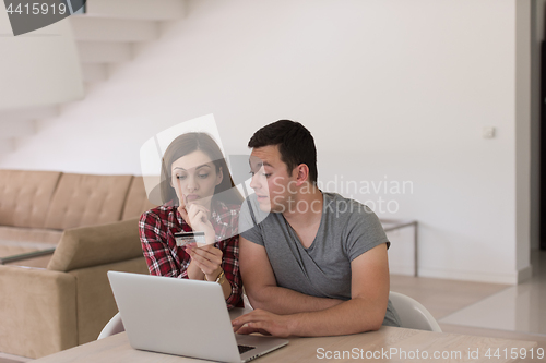 Image of happy young couple buying online