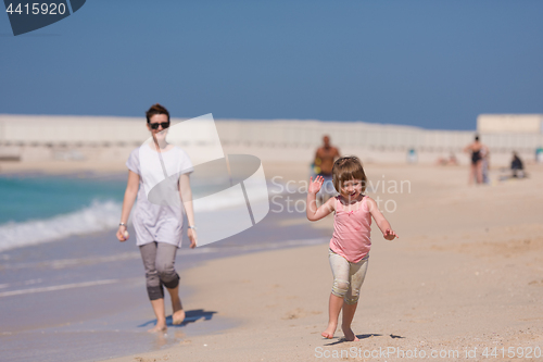 Image of mother and daughter running on the beach