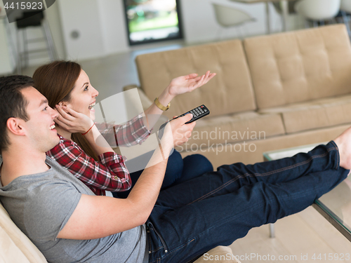 Image of Young couple on the sofa watching television