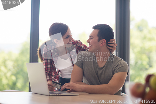 Image of happy young couple buying online