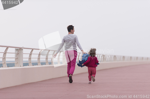 Image of mother and cute little girl on the promenade by the sea