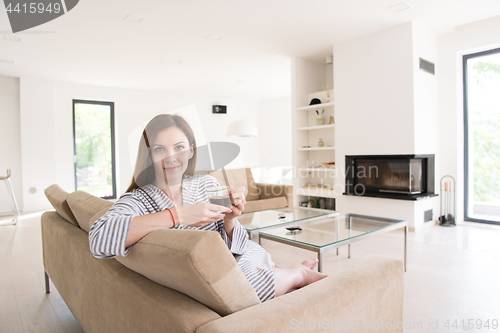 Image of young woman in a bathrobe enjoying morning coffee