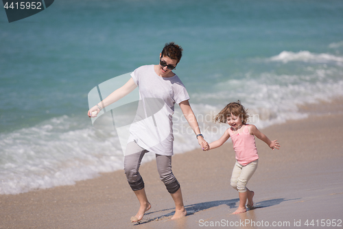 Image of mother and daughter running on the beach