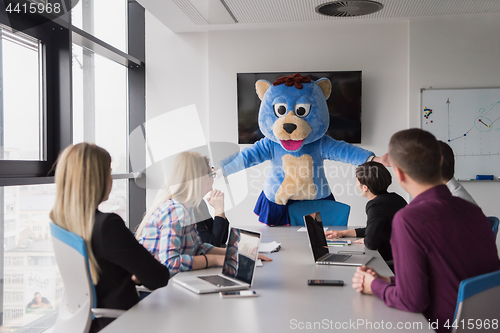 Image of boss dresed as bear having fun with business people in trendy of