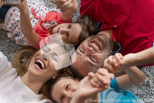 Image of happy family lying on the floor