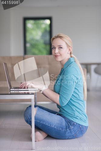 Image of young women using laptop computer on the floor