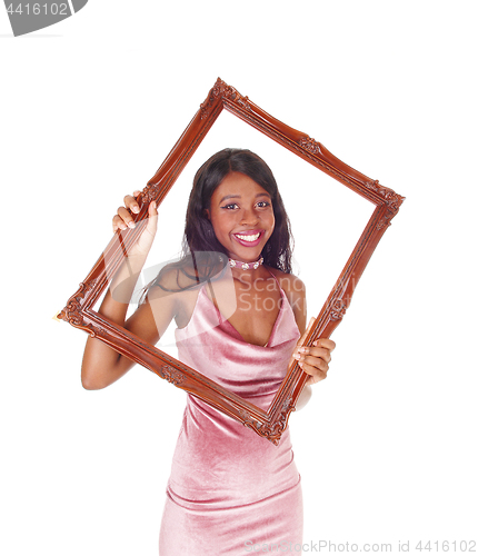 Image of Smiling woman looking trough picture frame