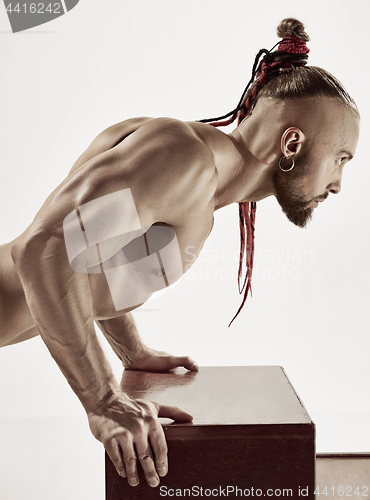 Image of the handsome guy is wrung out on a table in the gym