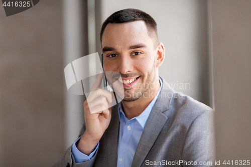 Image of businessman calling on smartphone at office