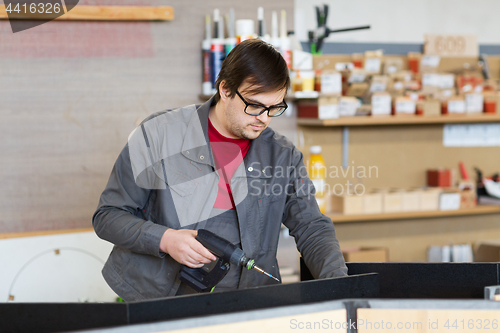 Image of assembler with screwdriver making furniture